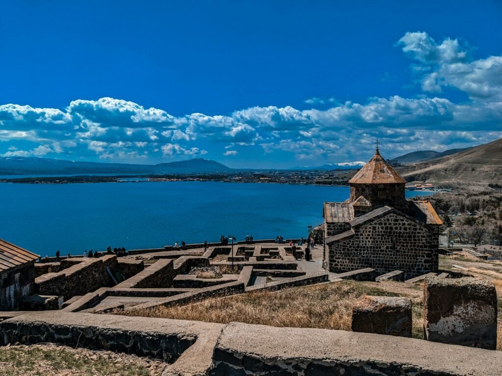Sevanavank monastery overlooking deep-blue Lake Sevan from the peninsula, with stone terraces and distant mountains, Armenia