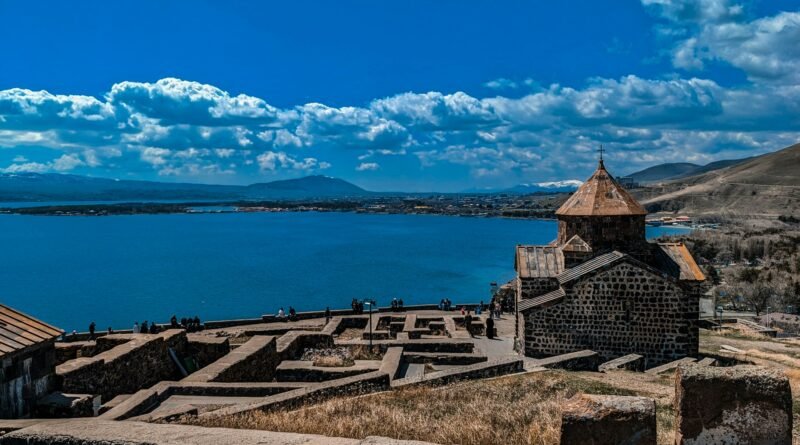 Sevanavank monastery overlooking deep-blue Lake Sevan from the peninsula, with stone terraces and distant mountains, Armenia