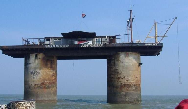 Sealand sea-fort platform on twin concrete towers above the North Sea, displaying its flag and antenna structures.