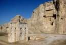 Naqsh-e Rustam necropolis showing the white Kaaba-ye Zartosht tower in the foreground and an Achaemenid cliff-tomb façade carved into the limestone cliff at Fars Province, Iran.