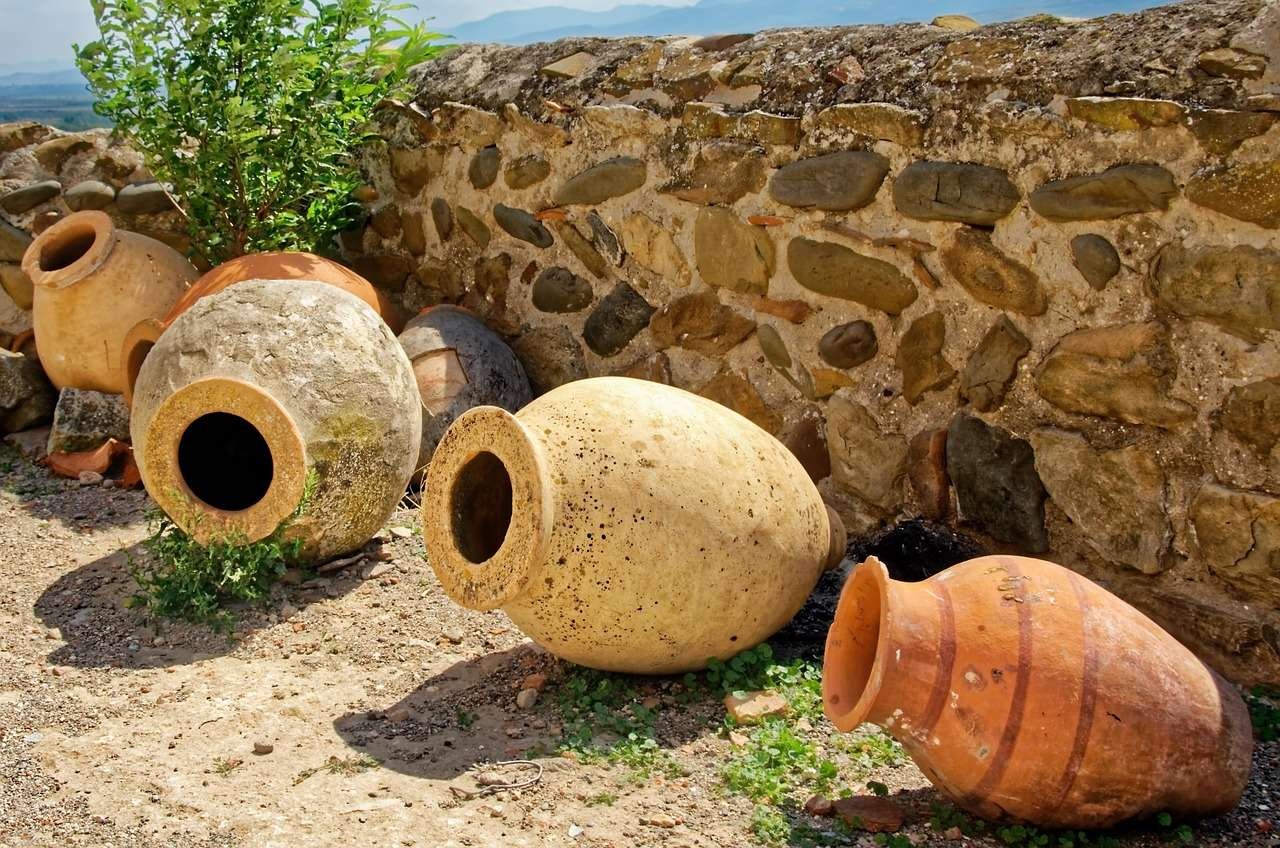Traditional Georgian clay qvevri amphoras against a stone wall