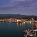 Batumi Black Sea coastline at dusk with illuminated port and mountains in the background