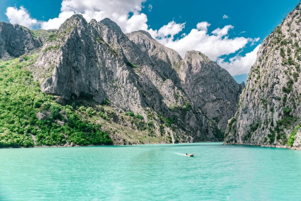 Komani Lake in northern Albania with steep rocky cliffs and turquoise water