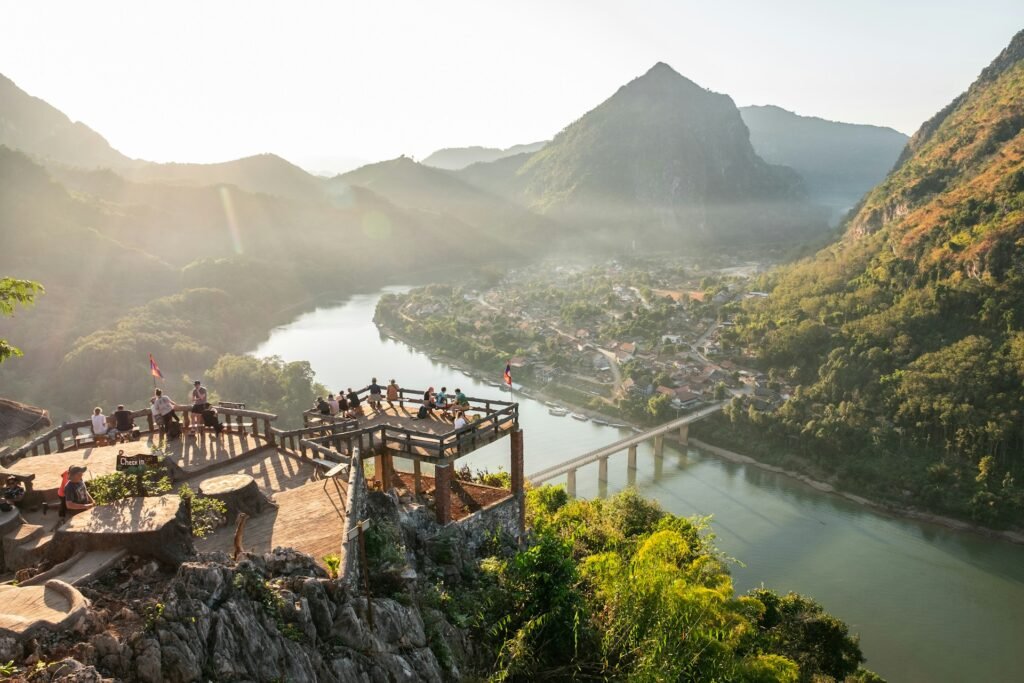 Scenic view over Nong Khiaw, Laos with Nam Ou River, mountains, and wooden viewpoint at sunset