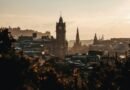 Sunset skyline of Edinburgh, Scotland, with the Balmoral Clock Tower, the gothic Scott Monument, and Edinburgh Castle rising above Old and New Town rooftops.