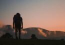 Solo traveler with backpack hiking at sunrise in the mountains, symbolizing independence and adventure
