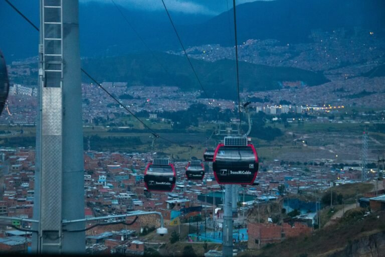 TransMiCable cabins over Ciudad Bolívar, Bogotá, linking hillside barrios to the city at dusk