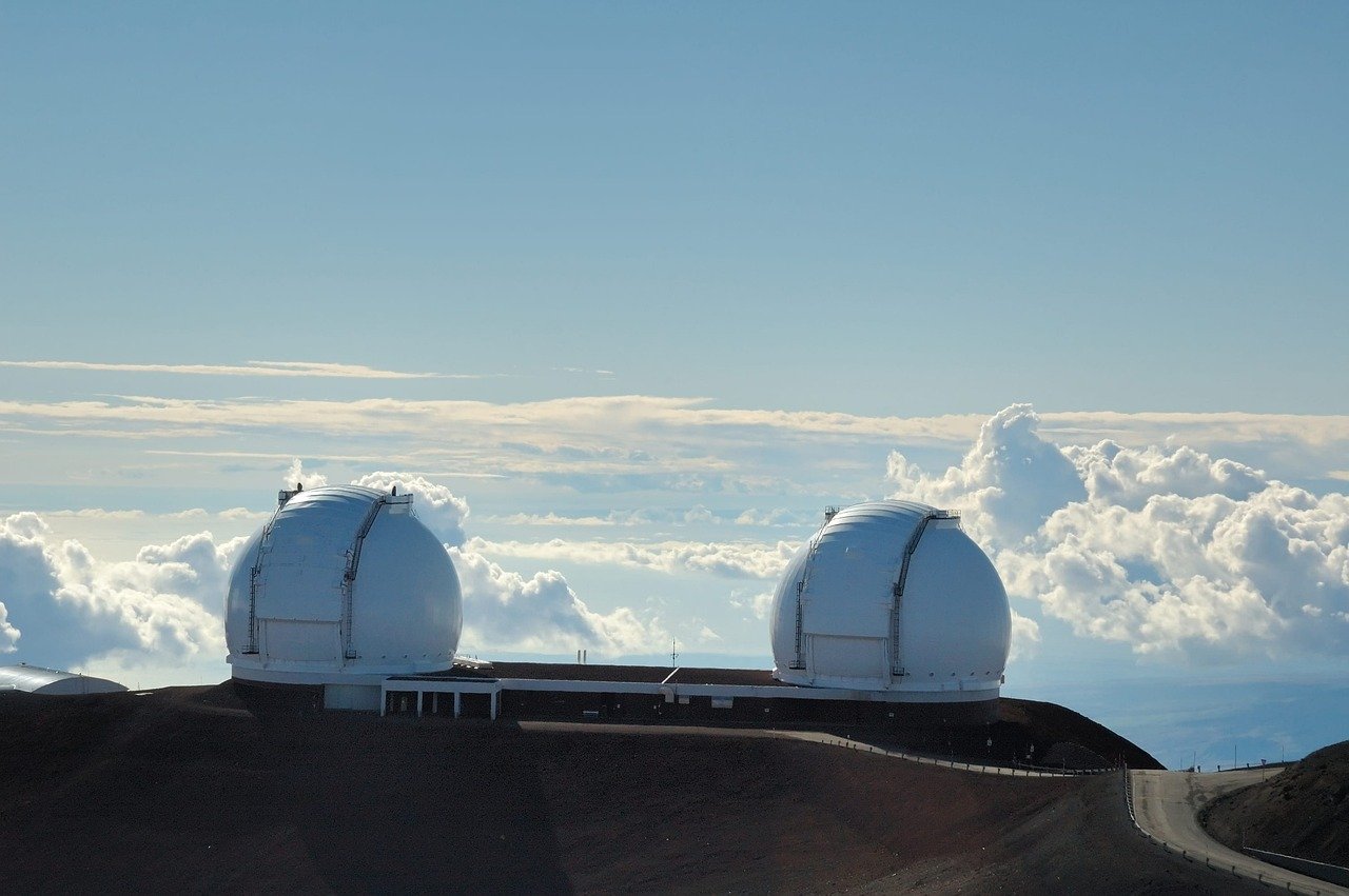 Twin Keck Observatory domes on Mauna Kea’s summit above the clouds, Hawaiʻi Island — world-class telescopes on the tallest mountain from base to summit