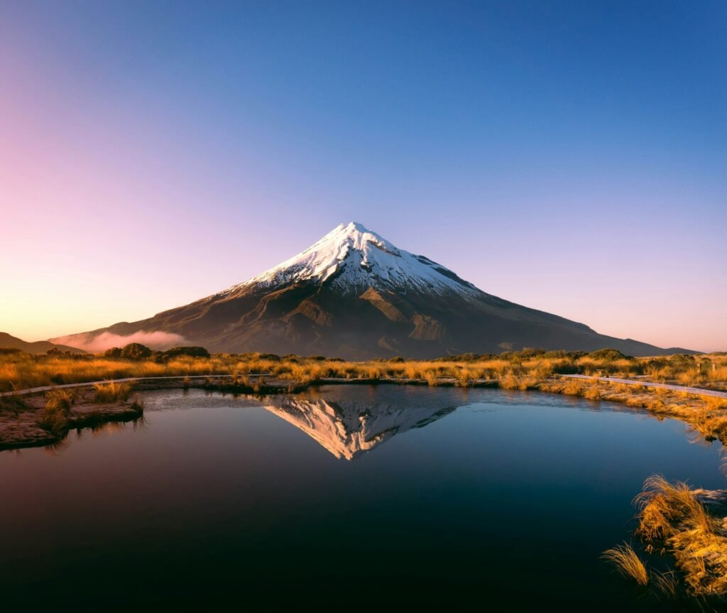 Taranaki reflected in Pouakai Tarn at sunrise, Taranaki, New Zealand.