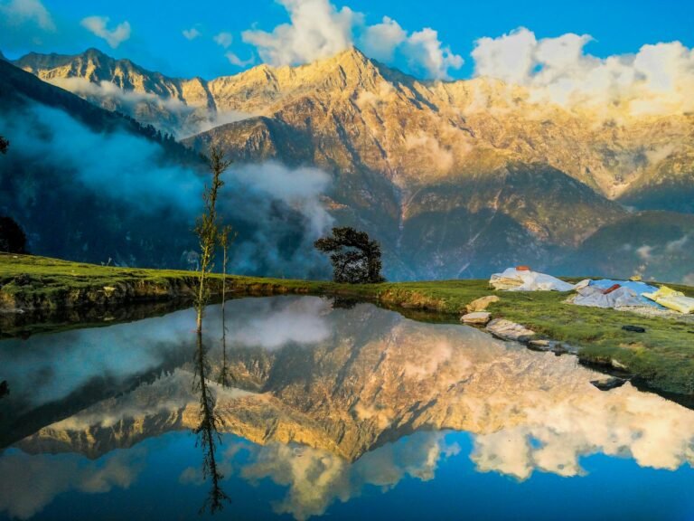 Sunrise on the Dhauladhar Range reflected in a hilltop pond at Triund, Himachal Pradesh, India.