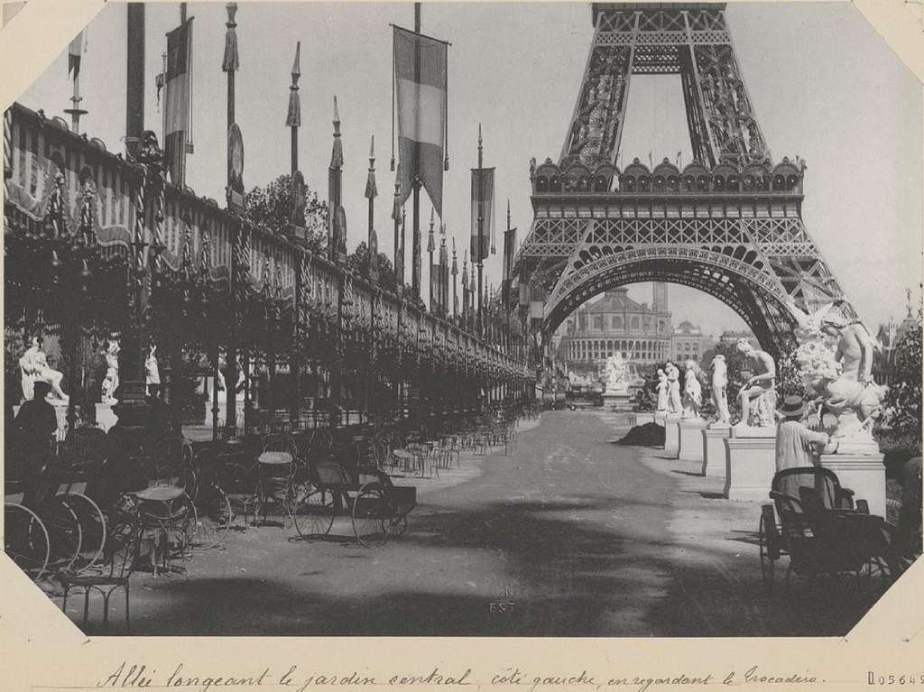 Processional alley with flags and statues leading to the Eiffel Tower at the 1889 fair