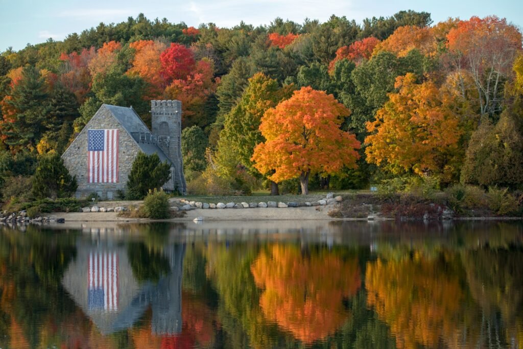 Old Stone Church (1891) reflected in Wachusett Reservoir amid peak fall foliage, West Boylston, Massachusetts, USA.