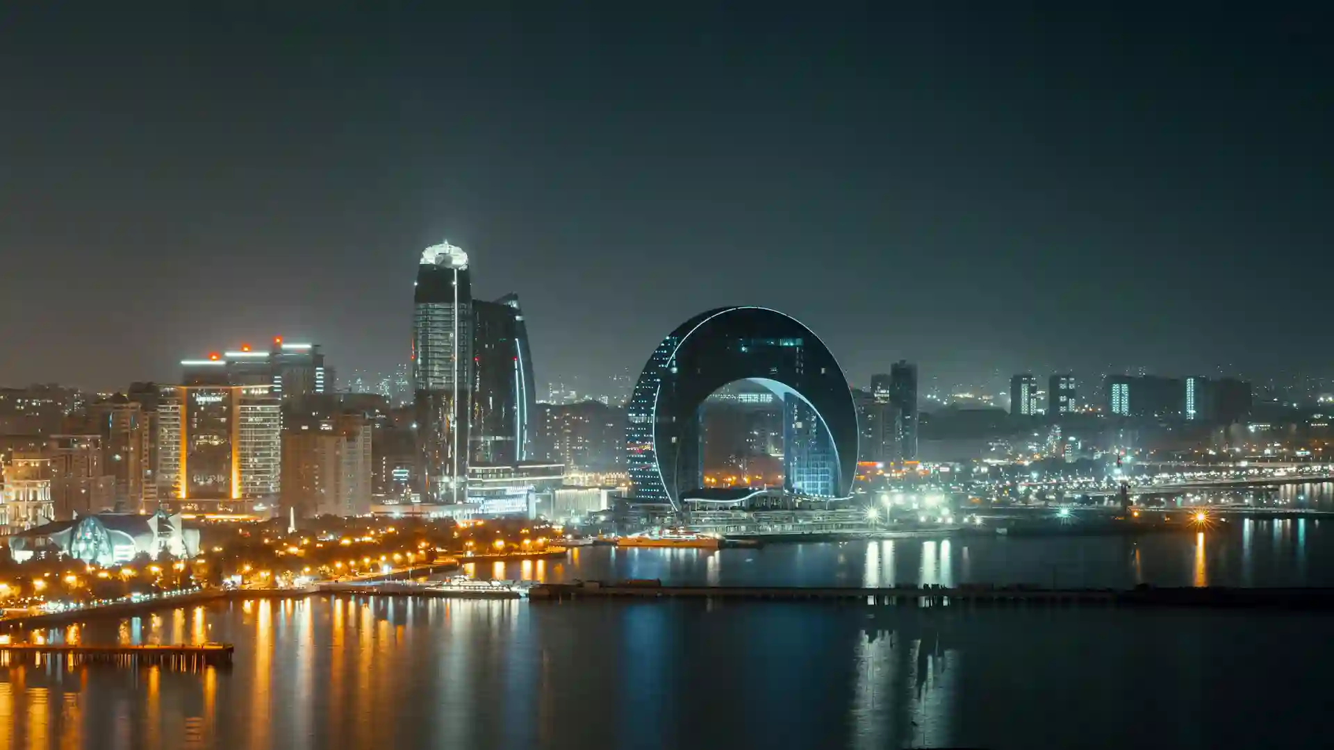 Night panorama of Baku skyline with modern towers and the Caspian Sea waterfront in Azerbaijan.