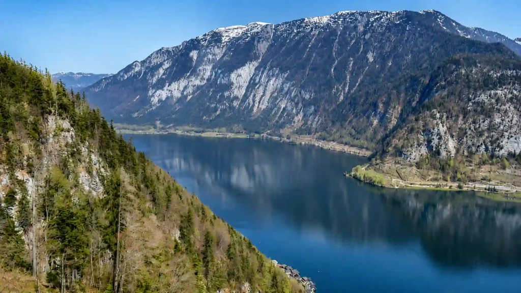 Lake Hallstatt filling a narrow glacial basin between steep forested mountains in Upper Austria.